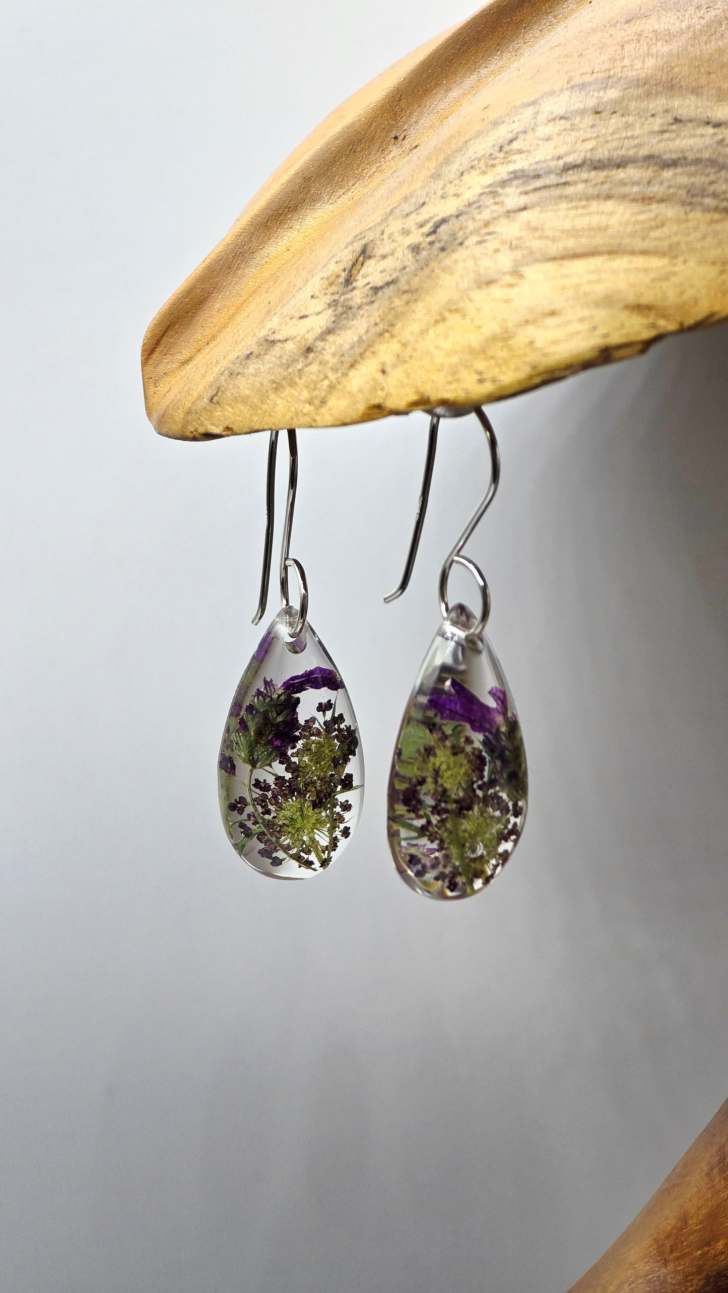 Earrings featuring wildflower specimens of Preserved Lavender and Chocolate Queen Annes Lace, secured on a .925 Sterling Silver Shepherd Hook