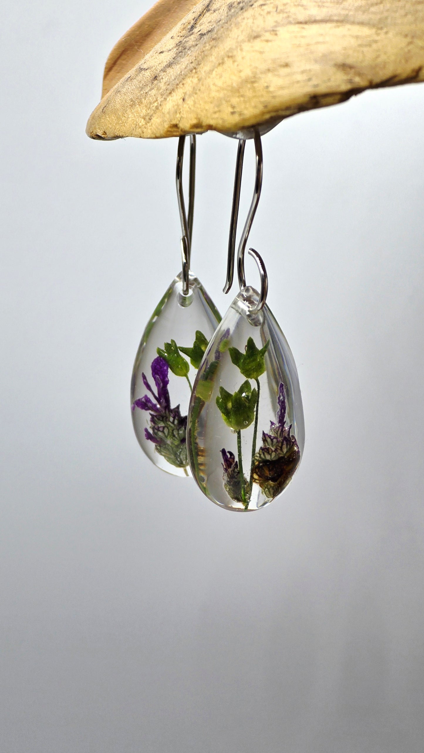 Earrings featuring wildflower specimens of Preserved Primula and Lavender, secured on a .925 Sterling Silver Shepherd Hook