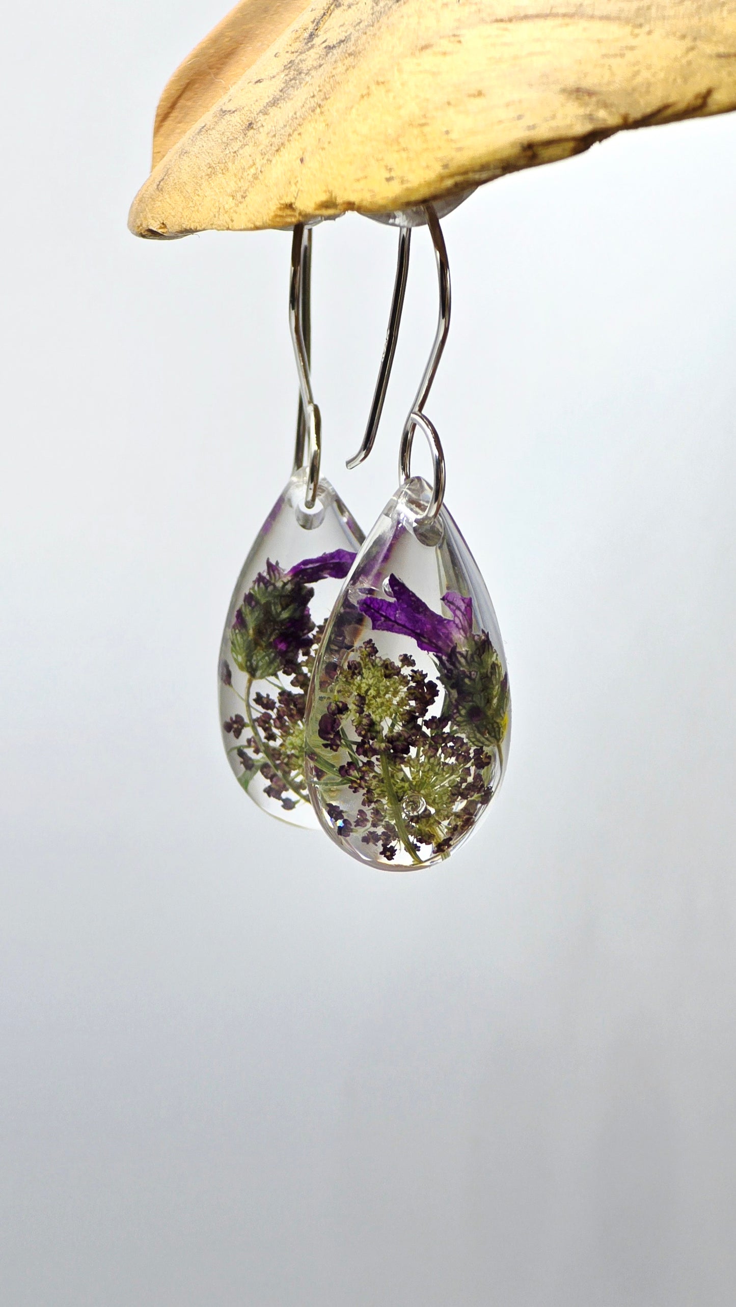Earrings featuring wildflower specimens of Preserved Lavender and Chocolate Queen Annes Lace, secured on a .925 Sterling Silver Shepherd Hook