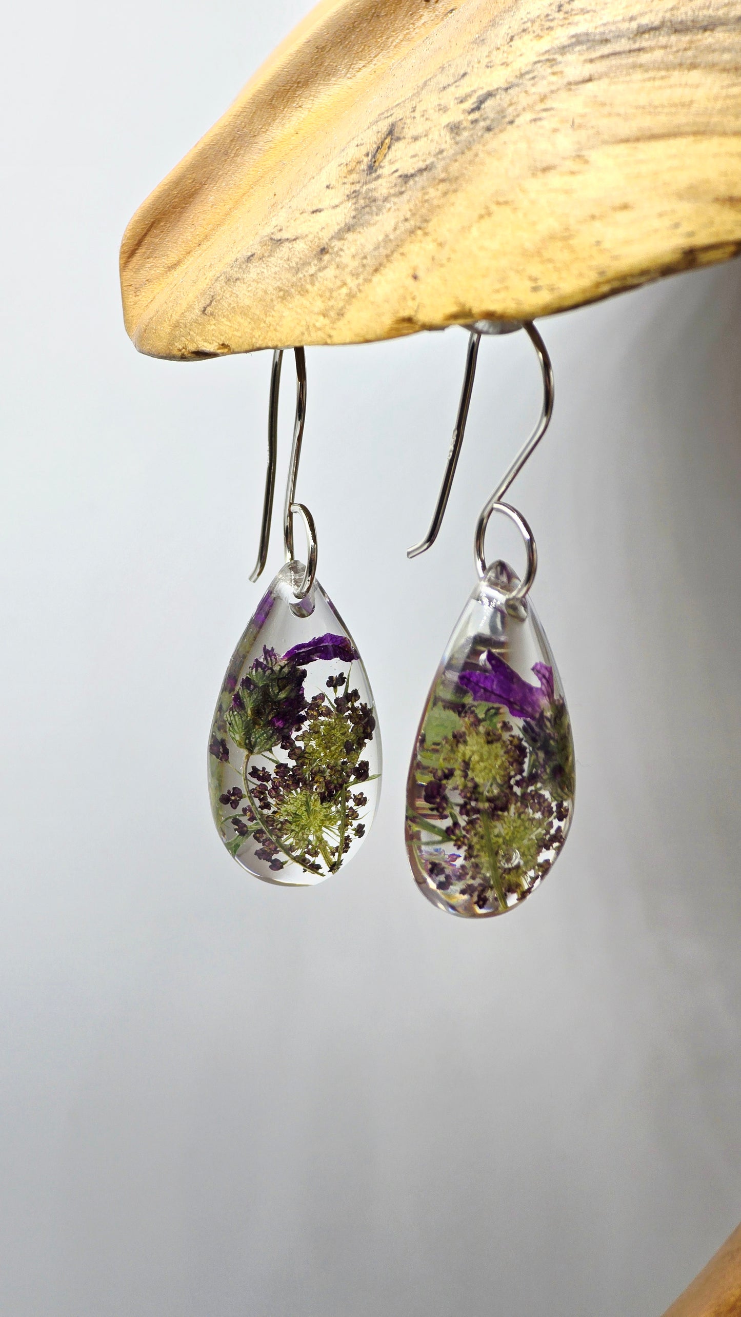 Earrings featuring wildflower specimens of Preserved Lavender and Chocolate Queen Annes Lace, secured on a .925 Sterling Silver Shepherd Hook
